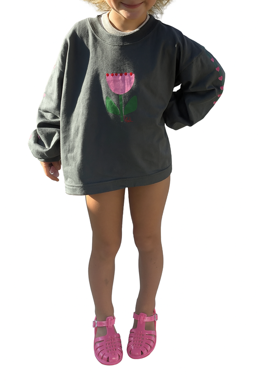 kids long sleeve tshirt featuring a belle sleeve with chunky cuffs detail oversized fit with bold pink green and red flower graphic hand painted logo in white on a charcoal organic cotton tshirt comfortable boxxy fit soft fabric made for playing fun and adventure