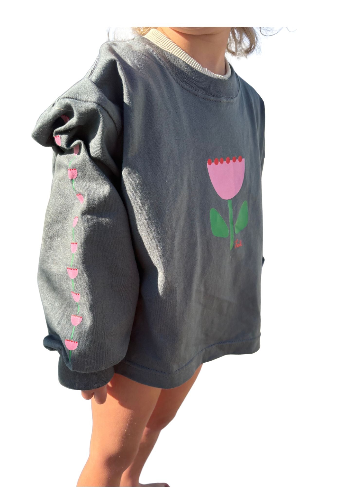 kids long sleeve tshirt featuring a belle sleeve with chunky cuffs detail oversized fit with bold pink green and red flower graphic hand painted logo in white on a charcoal organic cotton tshirt comfortable boxxy fit soft fabric made for playing fun and adventure