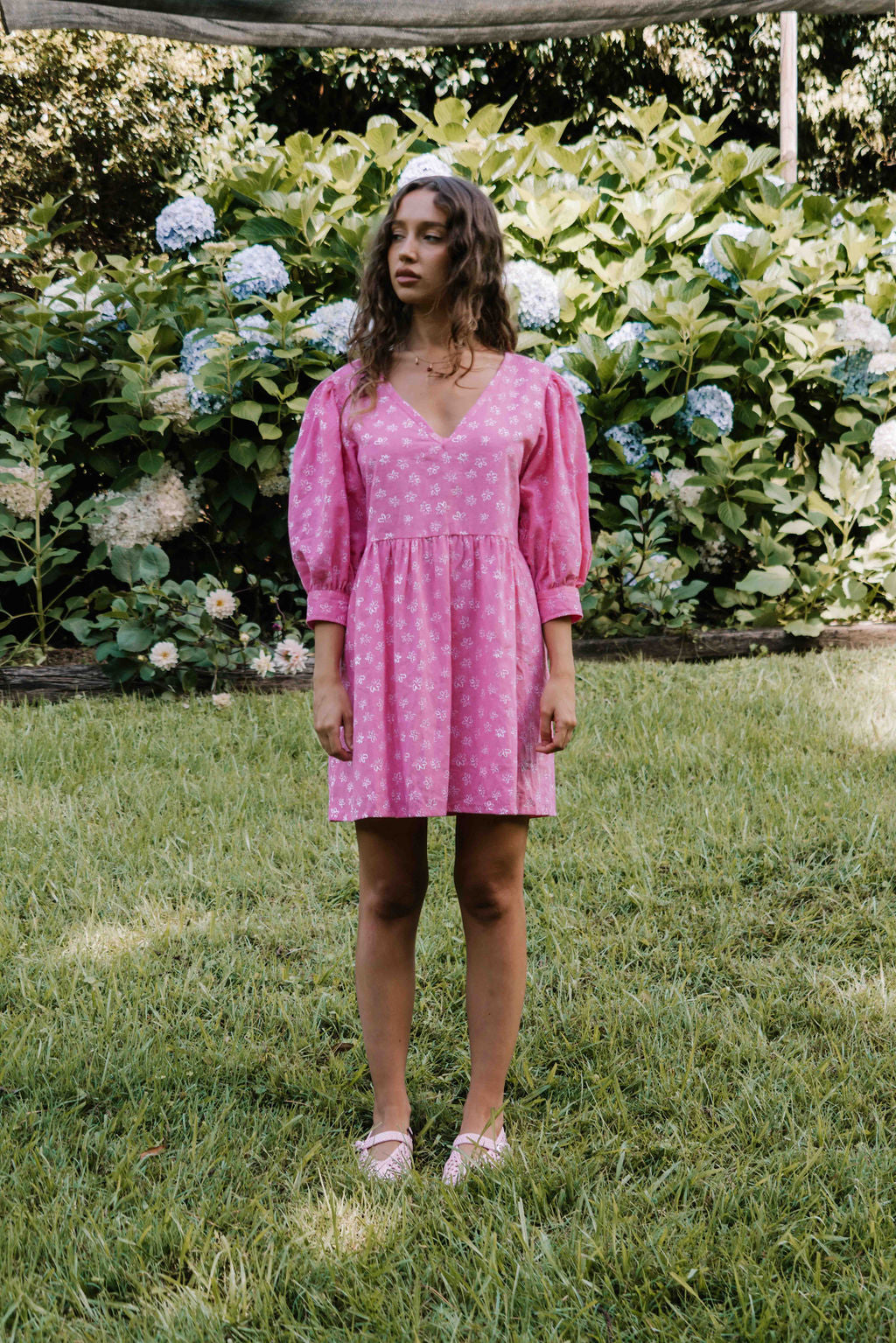 womens v neck mini smock made from 100% highest quality cotton linen. A flattering cut with an adjustable back tie. Puffed 3/4 sleeves and a drop waist with a short dress length. Super comfortable dress, adjustable back tie and in a floral flower print in bright candy pink.