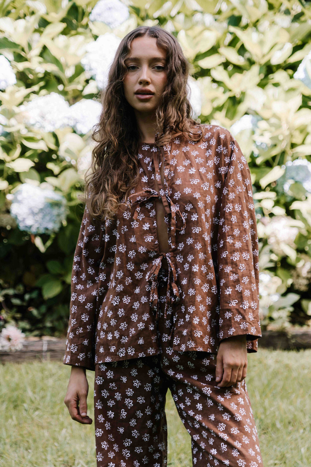 tie front blouse, cotton linen fabric, boxy fit, centre front ties, long sleeves to the wrist, white hand painted flower floral print on dark brown mocha colour, womens top