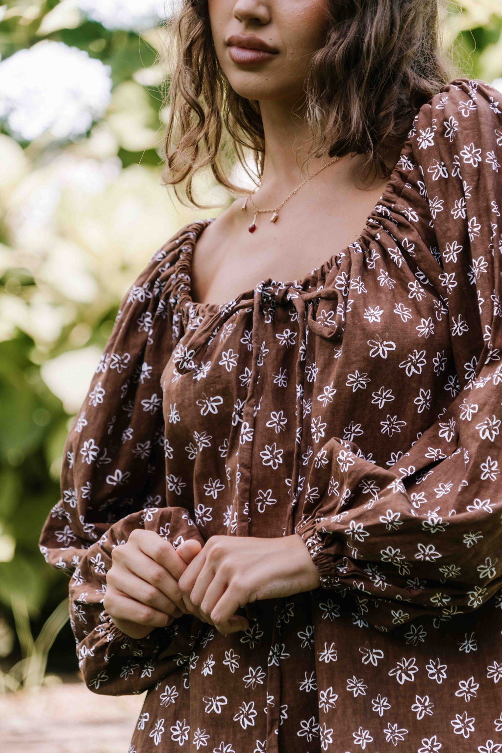 drawstring neckline shift mini dress with a statement balloon long sleeve with elastic wrists, rounded neckline with adjustable bow tie at the front. Hand painted white flower print on a dark mocha brown cotton linen fabric.