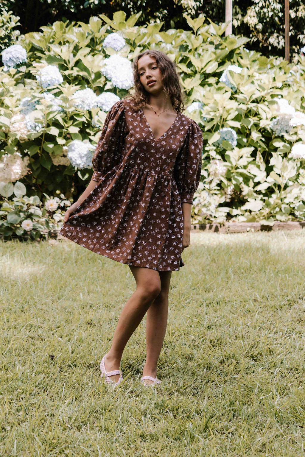 womens v neck mini smock made from 100% highest quality cotton linen. A flattering cut with an adjustable back tie. Puffed 3/4 sleeves and a drop waist with a short dress length. Super comfortable dress, adjustable back tie and in a floral flower print in mocha chocolate brown colour.