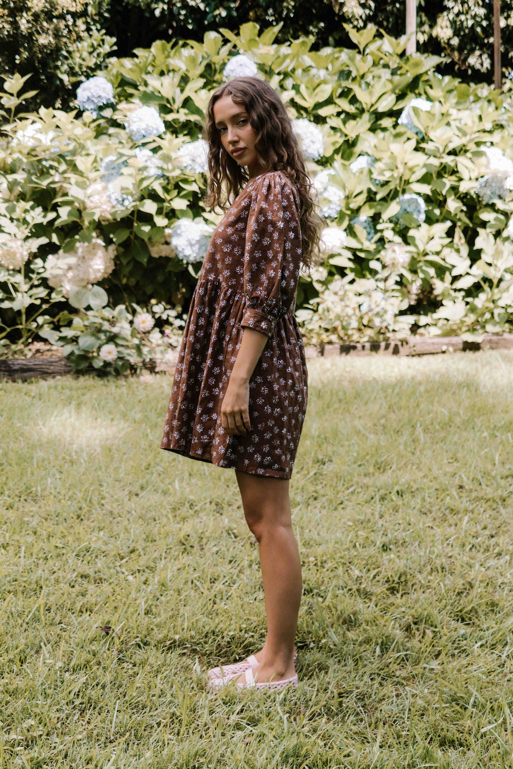 womens v neck mini smock made from 100% highest quality cotton linen. A flattering cut with an adjustable back tie. Puffed 3/4 sleeves and a drop waist with a short dress length. Super comfortable dress, adjustable back tie and in a floral flower print in mocha chocolate brown colour.