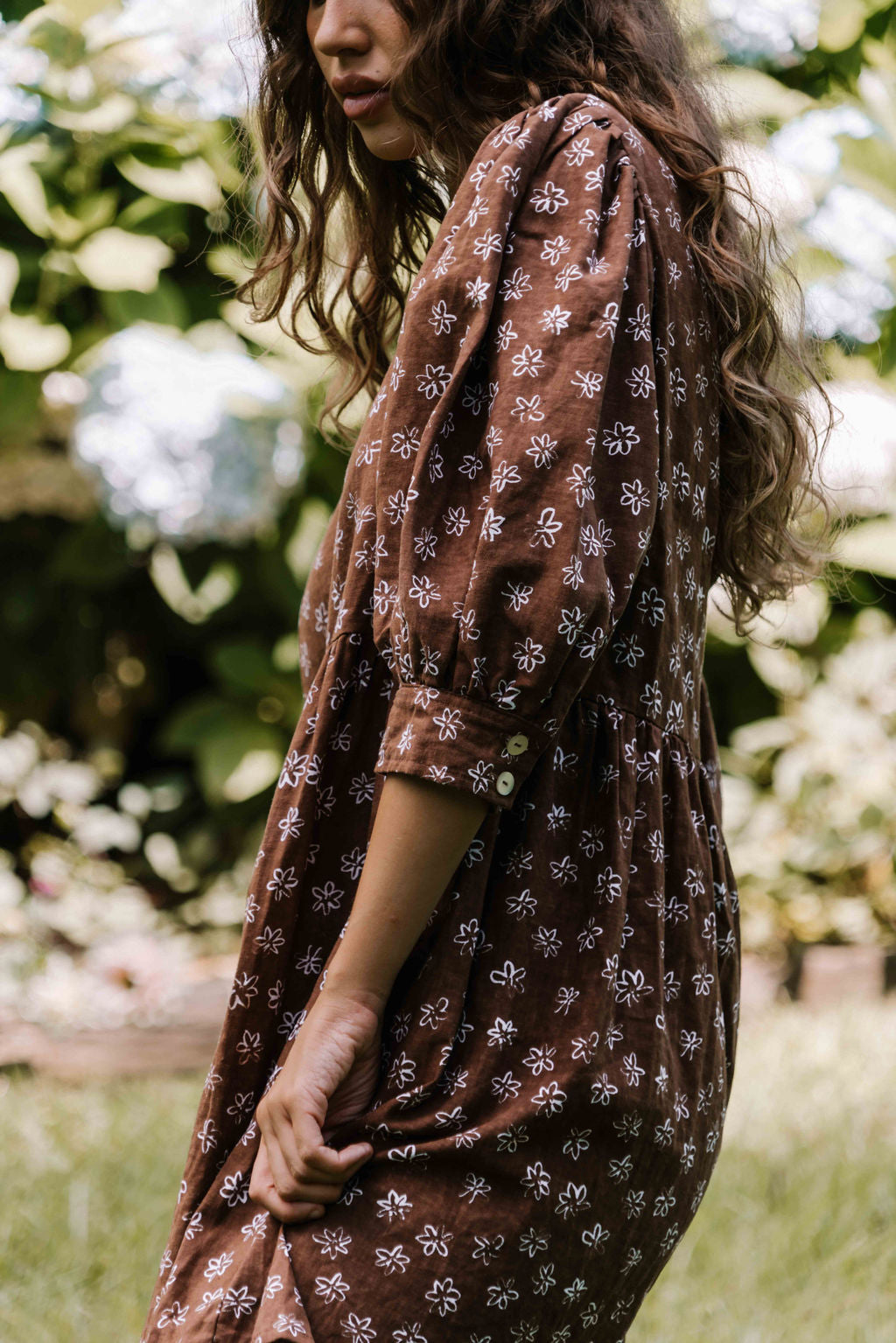 womens v neck mini smock made from 100% highest quality cotton linen. A flattering cut with an adjustable back tie. Puffed 3/4 sleeves and a drop waist with a short dress length. Super comfortable dress, adjustable back tie and in a floral flower print in mocha chocolate brown colour.