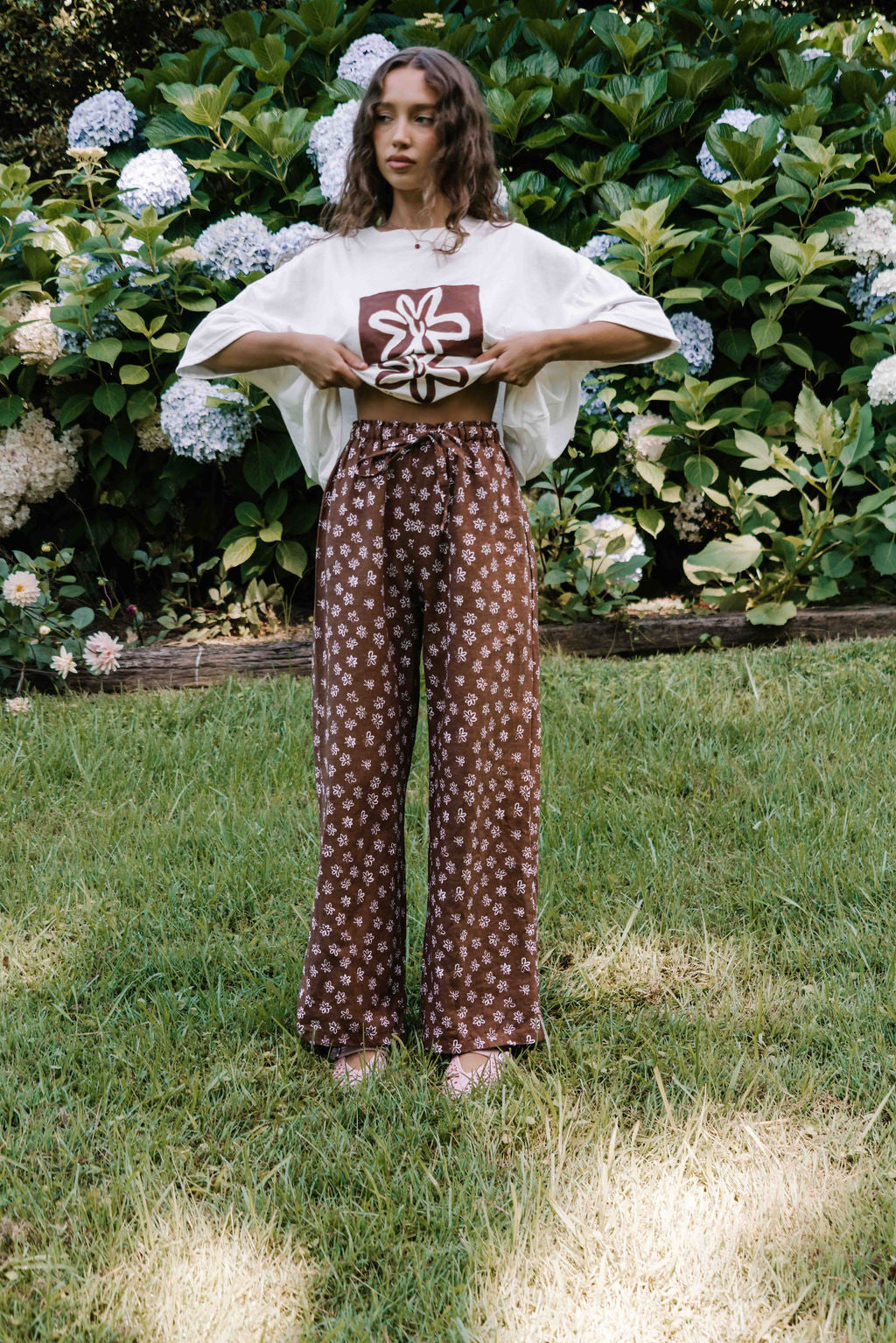 womens wide leg full length relaxed fit pant in a dark mocha brown cotton linen fabric with a hand painted flower print in white elastic waist with drawstring wide leg fit to the ankles