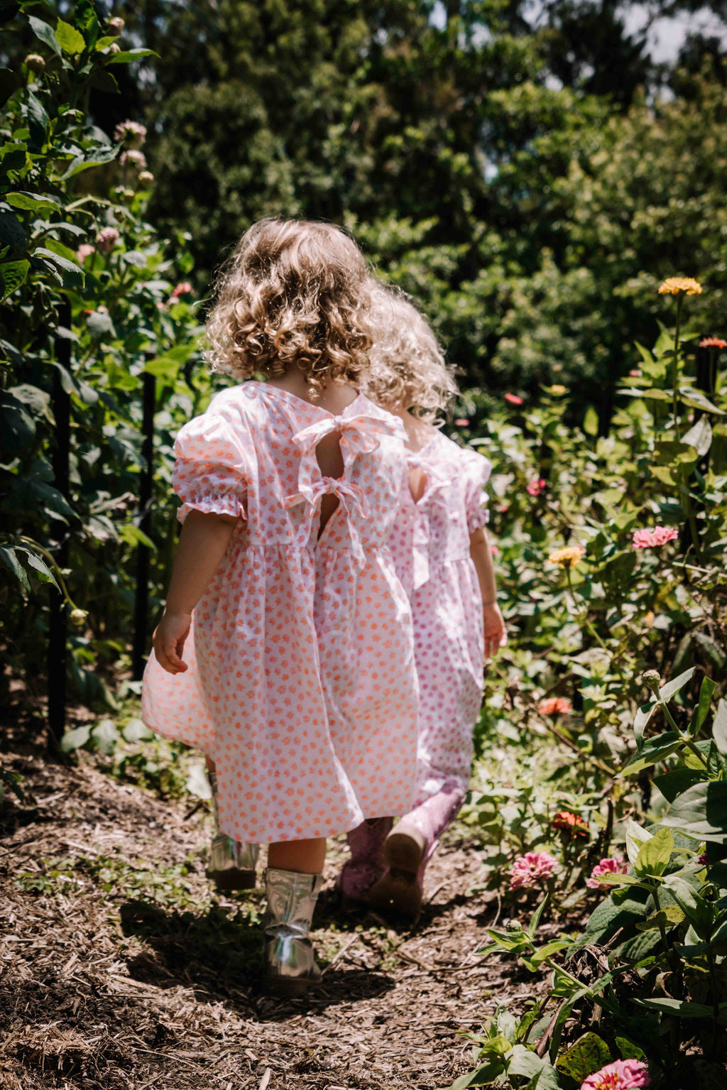 kids smock style dress in orange and white flower floral print with puff sleeves and adjustable back made from a cotton linen blend fabric thats soft