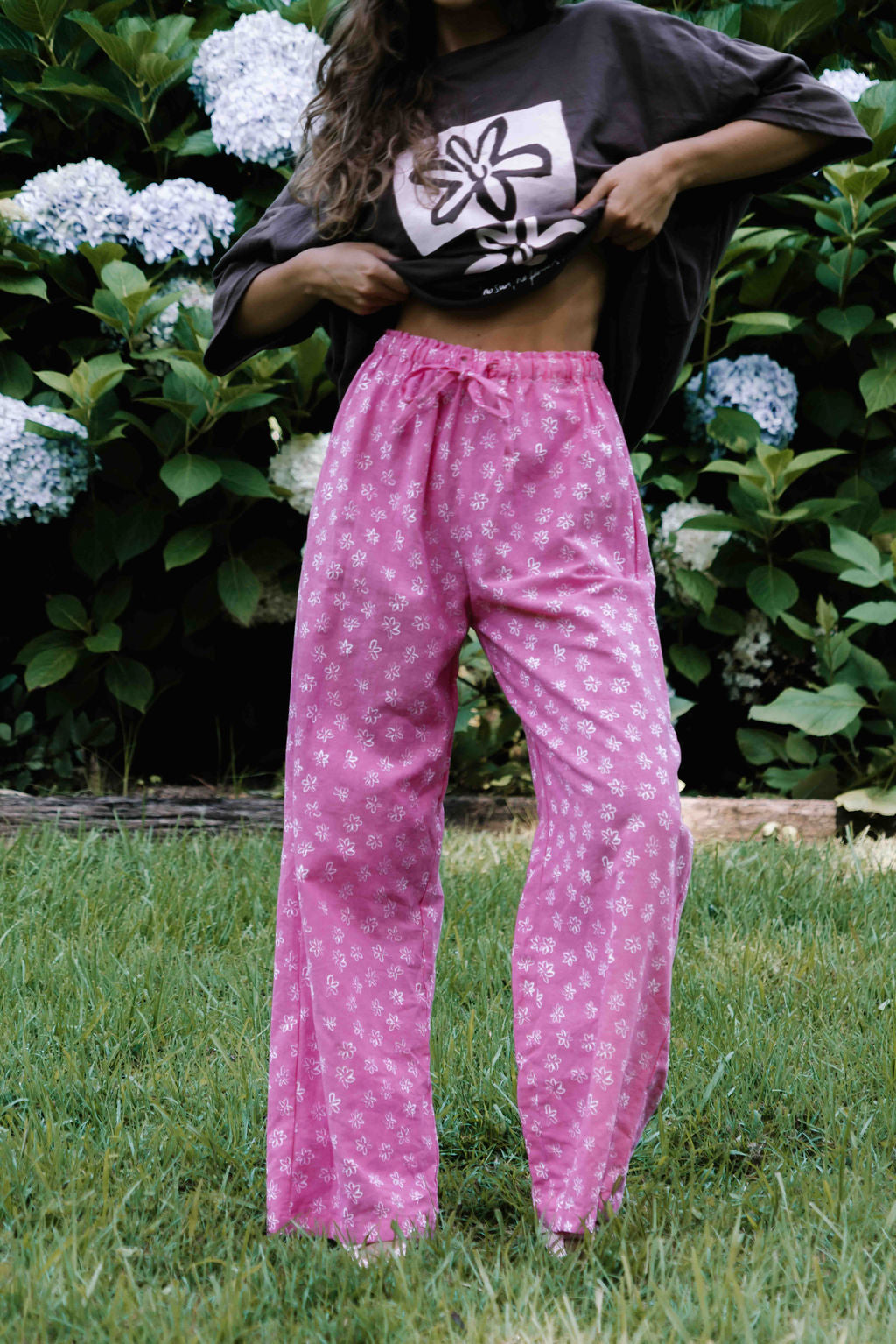 womens wide leg full length relaxed fit pant in abright candy pink cotton linen fabric with a hand painted flower print in white elastic waist with drawstring wide leg fit to the ankles