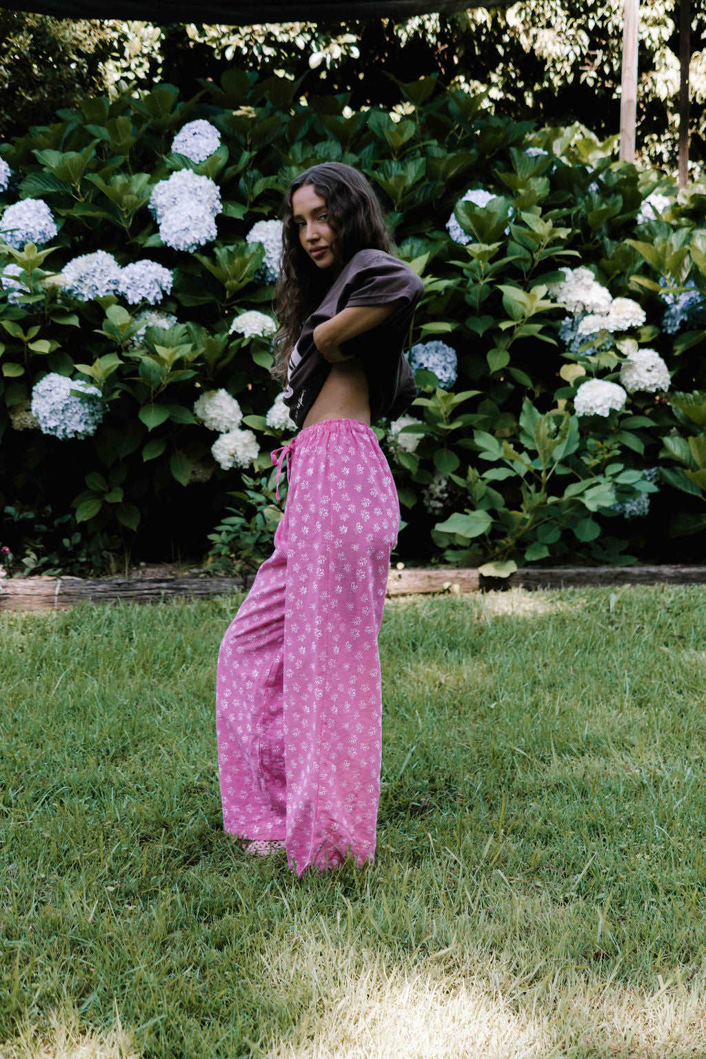 womens wide leg full length relaxed fit pant in abright candy pink cotton linen fabric with a hand painted flower print in white elastic waist with drawstring wide leg fit to the ankles