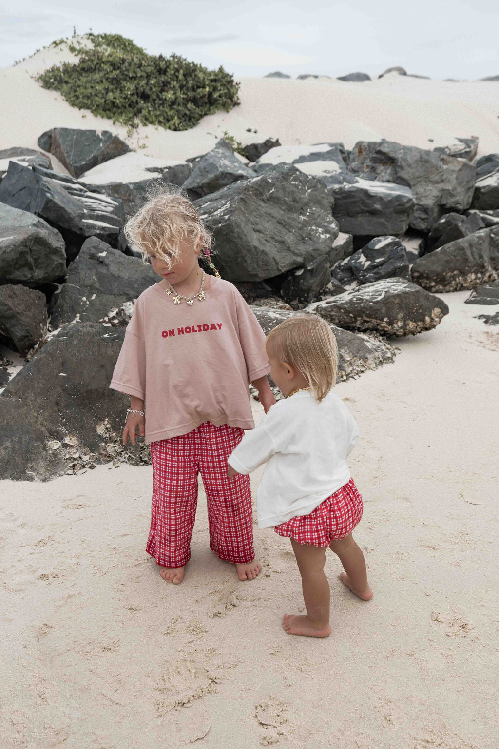 Children's t-shirt made from soft 100% orgaic cotton in a dusty pink oversized fit with red ‘ON HOLIDAY’ graphic. The shirt has a relaxed, comfy fit.