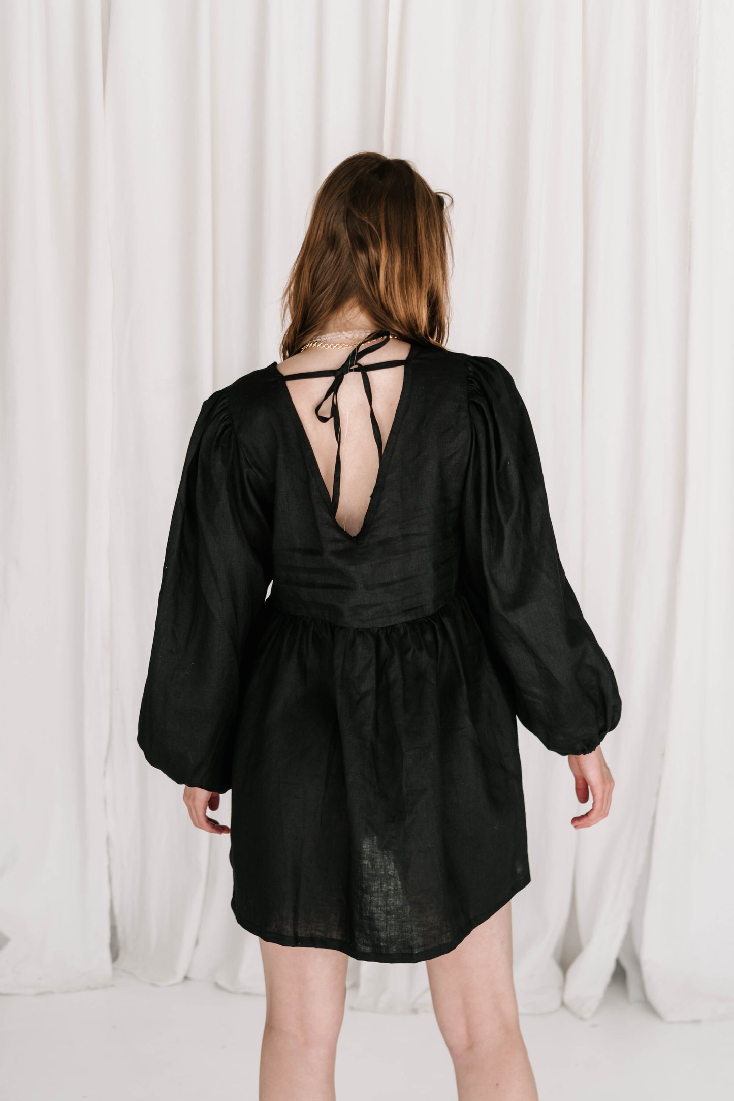 statement long puff sleeve black linen dress with v front, flattering shape, elastic cuffs flowy fit ties at back with adjustable straps short dress high quality linen