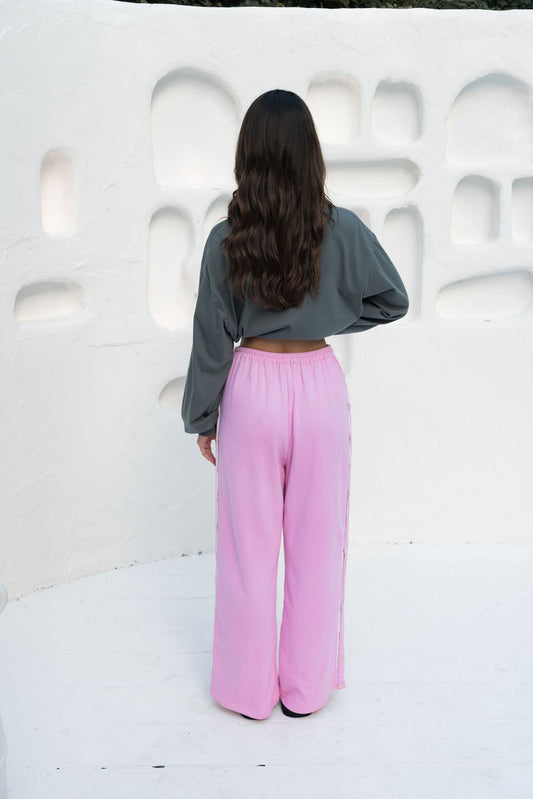 womens wide leg full length relaxed fit pant in a pink terry cotton fabric with a white drawstring and gold heart shape push studs down each leg wide leg fit to the ankle