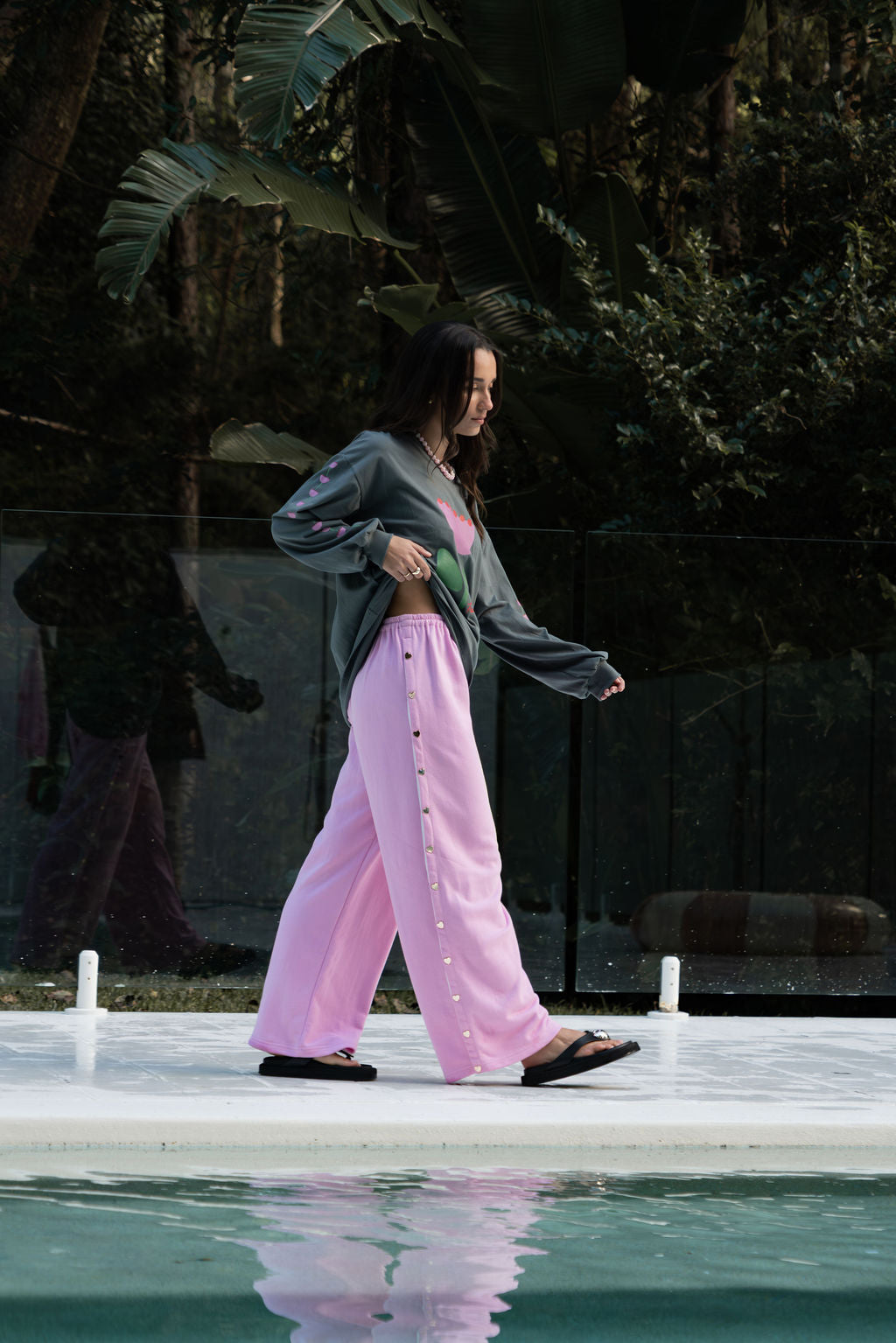 womens wide leg full length relaxed fit pant in a pink terry cotton fabric with a white drawstring and gold heart shape push studs down each leg wide leg fit to the ankle