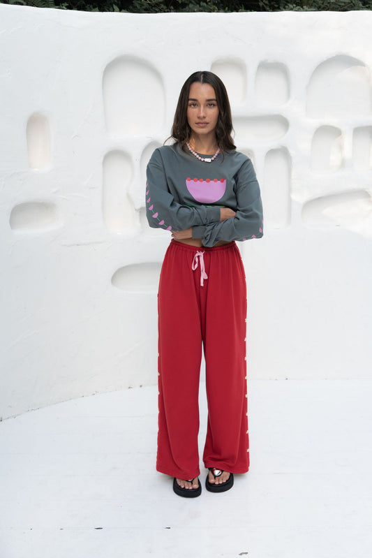 womens wide leg full length relaxed fit pant in a red terry cotton fabric with a pink drawstring and gold heart shape push studs down each leg wide leg fit to the ankle