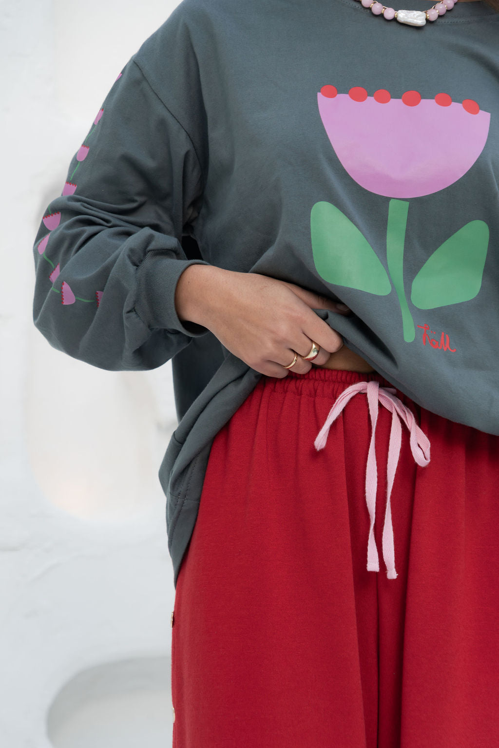 womens wide leg full length relaxed fit pant in a red terry cotton fabric with a pink drawstring and gold heart shape push studs down each leg wide leg fit to the ankle