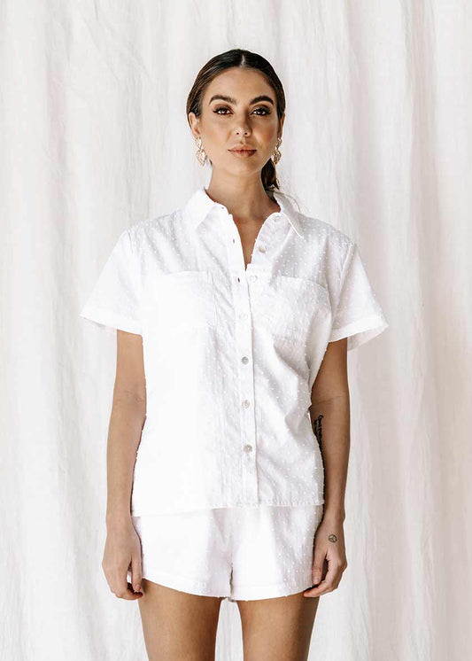 The new everyday blouse that will take you from sunrise to sunset. The new everyday blouse that will take you from sunrise to sunset, the Capri Shirt is so comfortable you’ll never want to take it off. Button up white textured blouse / shirt, short sleeve super soft. Shell button detail 100% high-quality cotton Beautiful textured dot fabric Pockets Split detail on sides Oversized fit Made from the highest quality cotton fabric, that is cool & breathable to wear ETHICALLY MADE IN INDONESIA