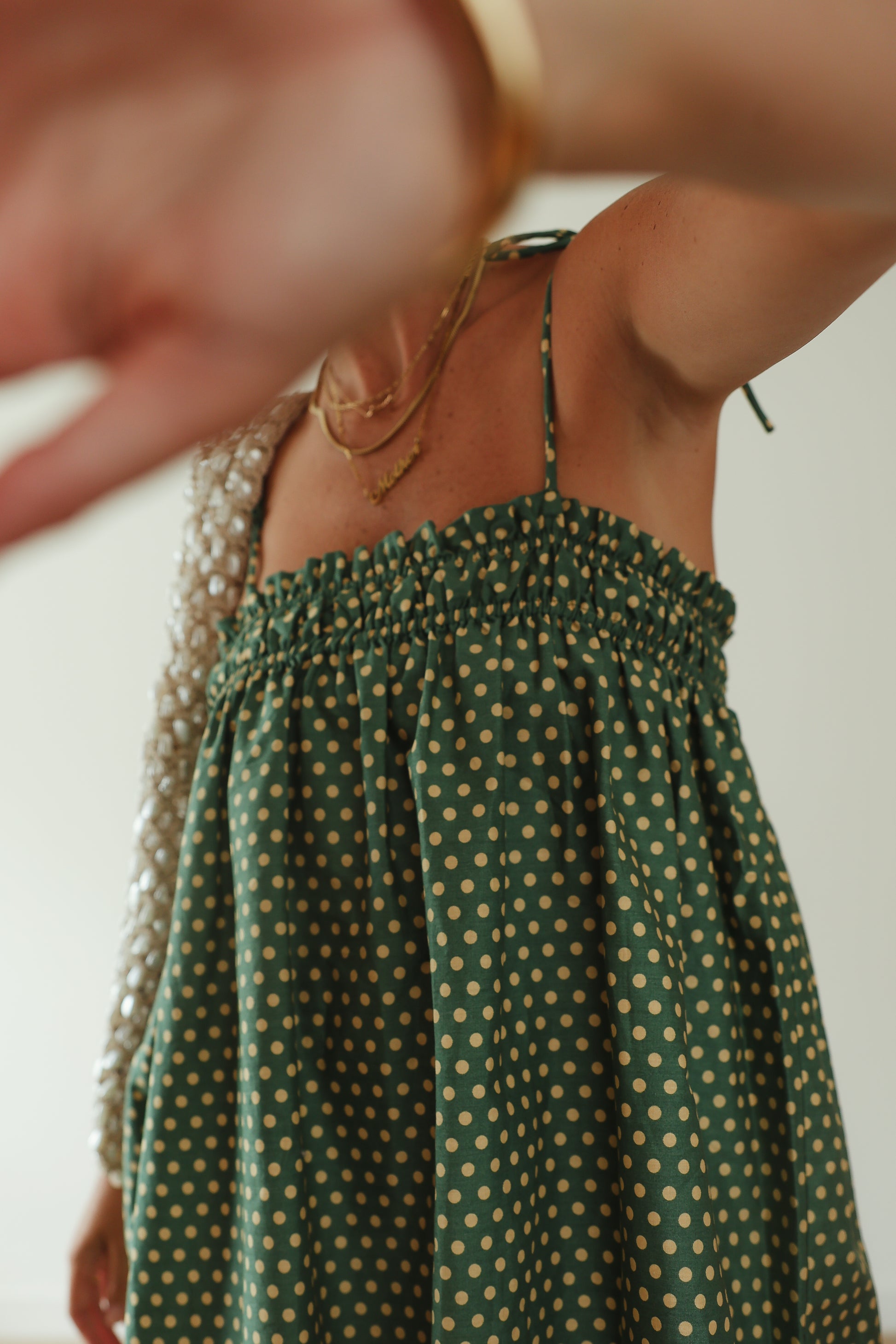 A stunning green mini smock dress with a ruched bust and adjustable spagetti shoulder straps that tie. The fabric is a light weight 100% soft cotton in vibrant green with white yellow polkadots.