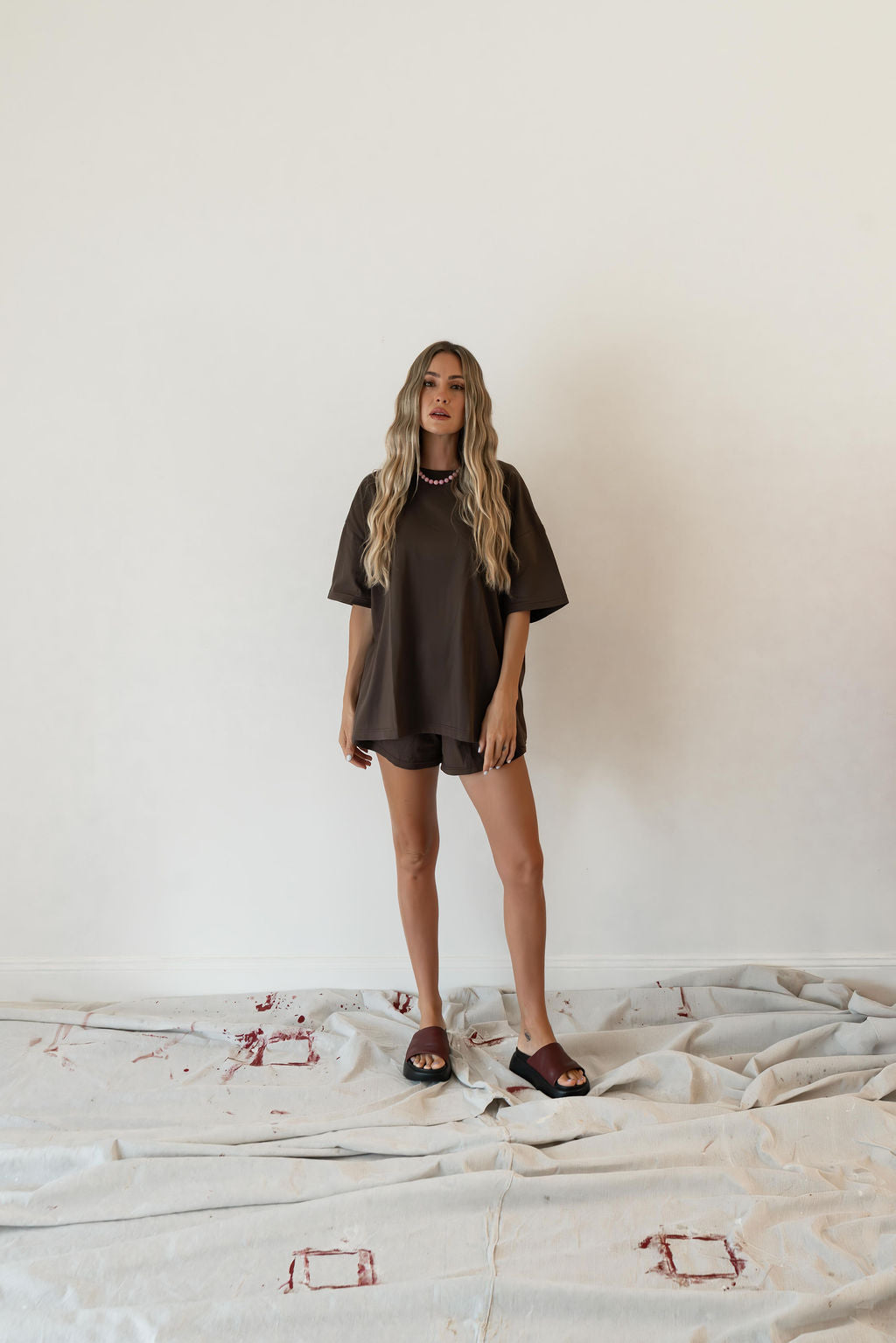 Model wears a relaxed fit oversized tshirt in a rich dark brown colour made from 100% organic cotton