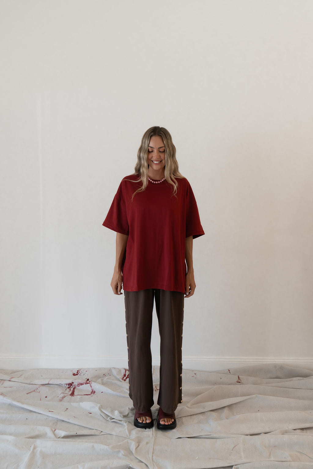 Model wears a relaxed fit oversized tshirt in a deep merlot red colour made from 100% organic cotton
