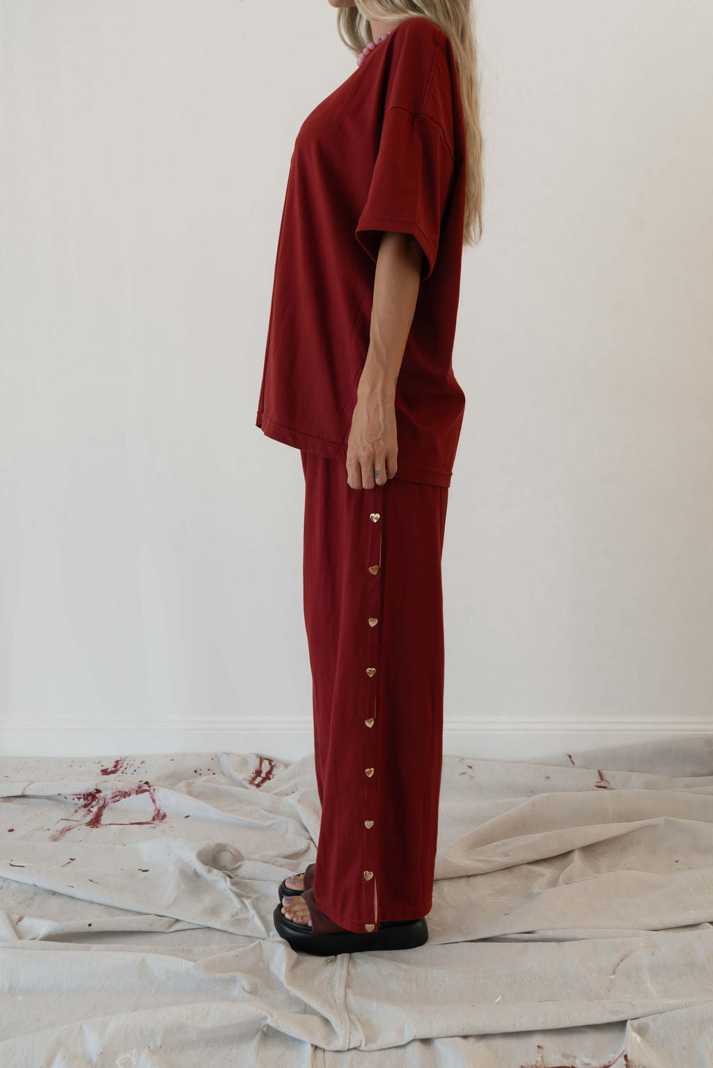 Model wears a relaxed fit oversized tshirt in a deep merlot red colour made from 100% organic cotton