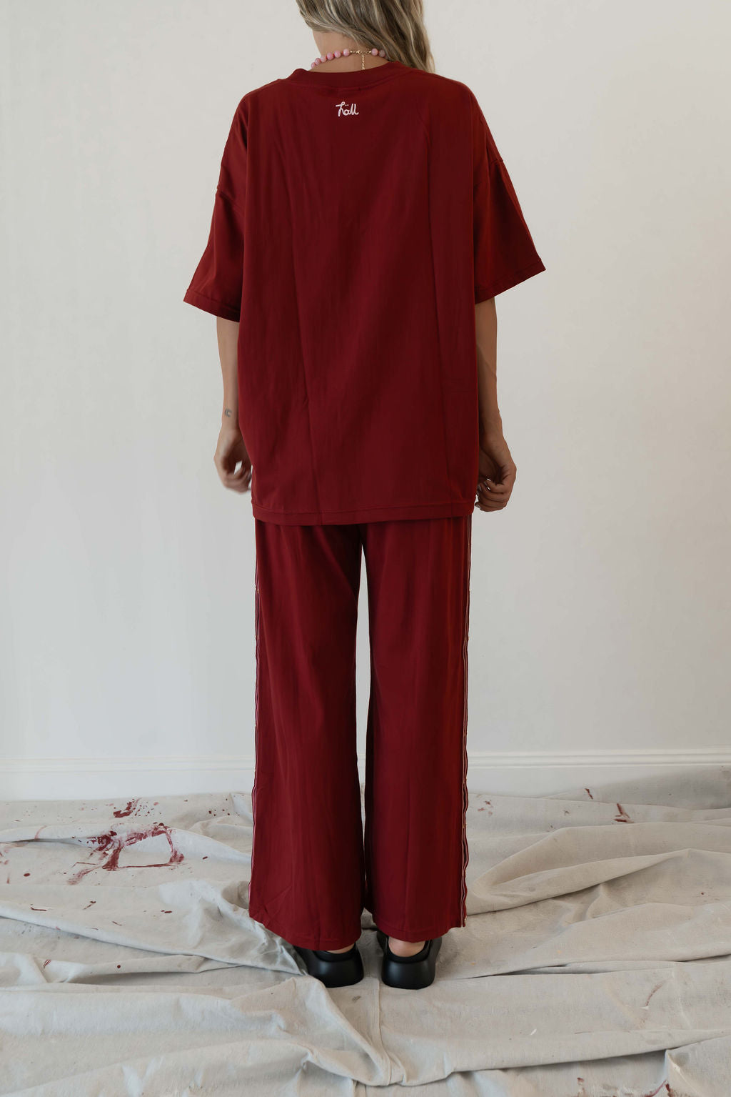Model wears a relaxed fit oversized tshirt in a deep merlot red colour made from 100% organic cotton