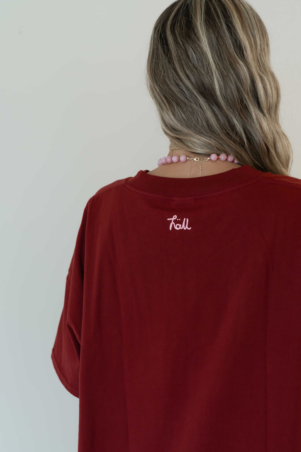Model wears a relaxed fit oversized tshirt in a deep merlot red colour made from 100% organic cotton