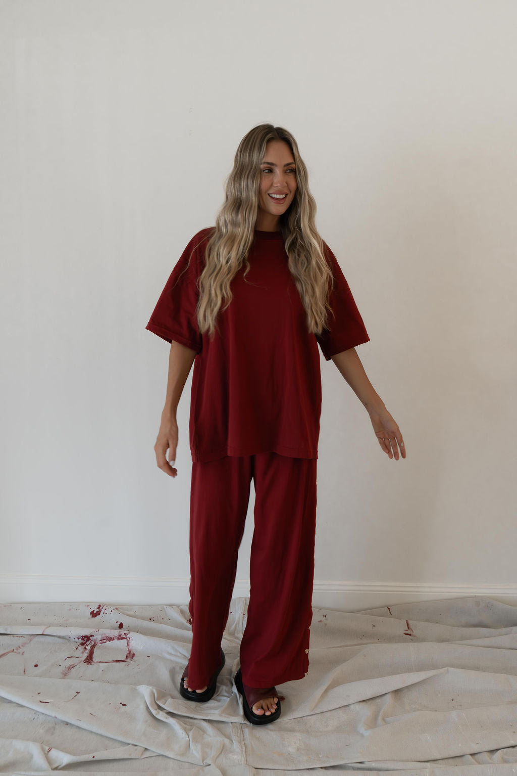Model wears a relaxed fit oversized tshirt in a deep merlot red colour made from 100% organic cotton