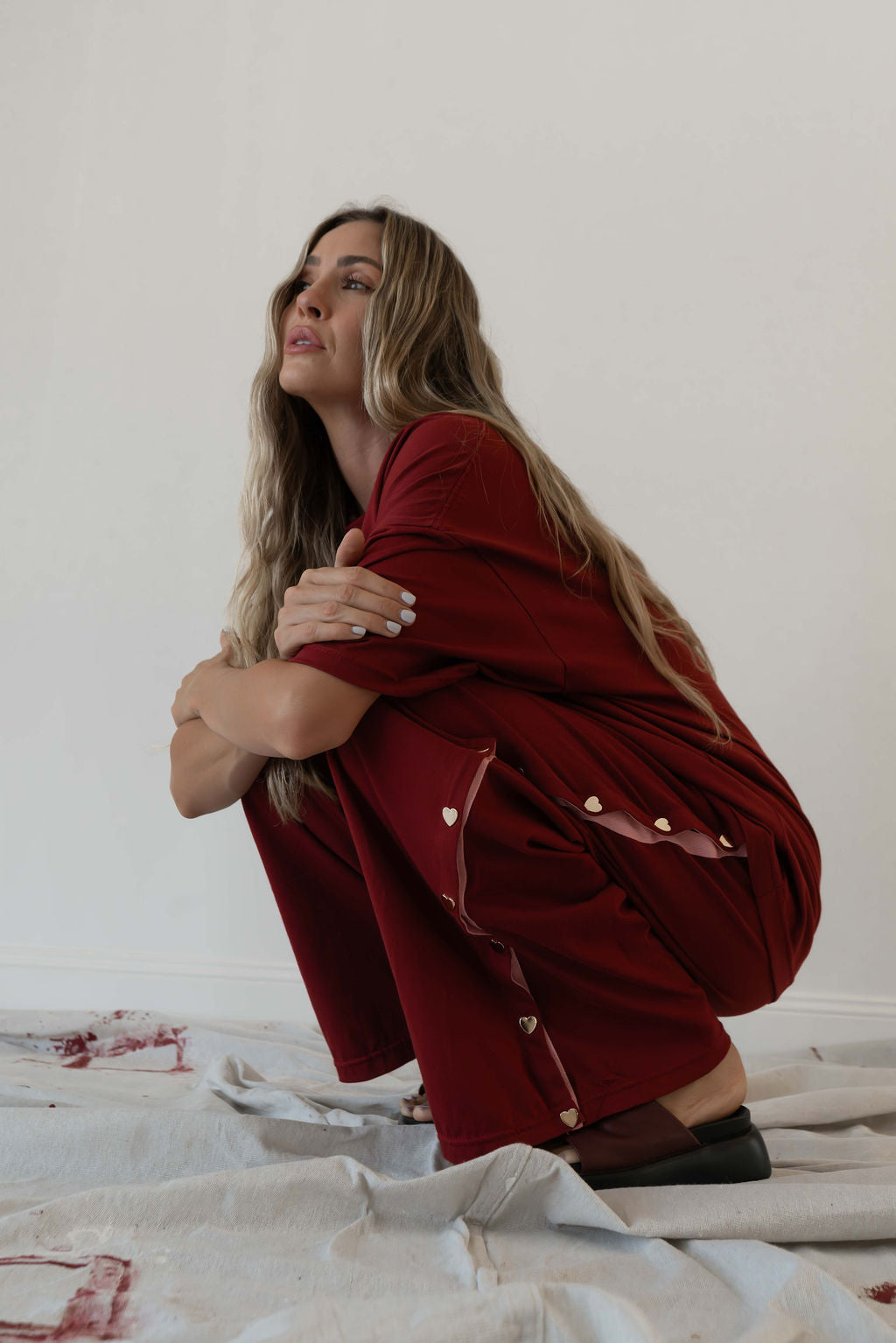 Model wears a two piece set in a deep merlot organic cotton relaxed wide leg pant with side gold heart snap buttons down the leg with an oversized tshirt also in the deep merlot red organic cotton