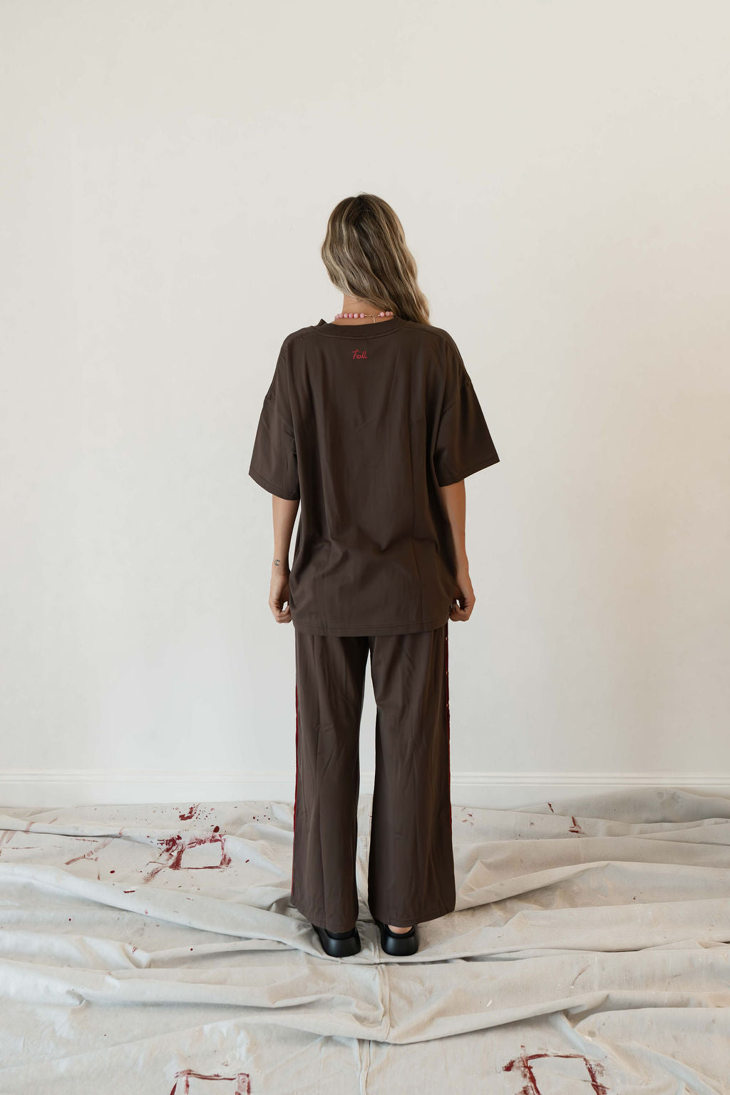 Model wears a relaxed fit oversized tshirt in a rich dark brown colour made from 100% organic cotton