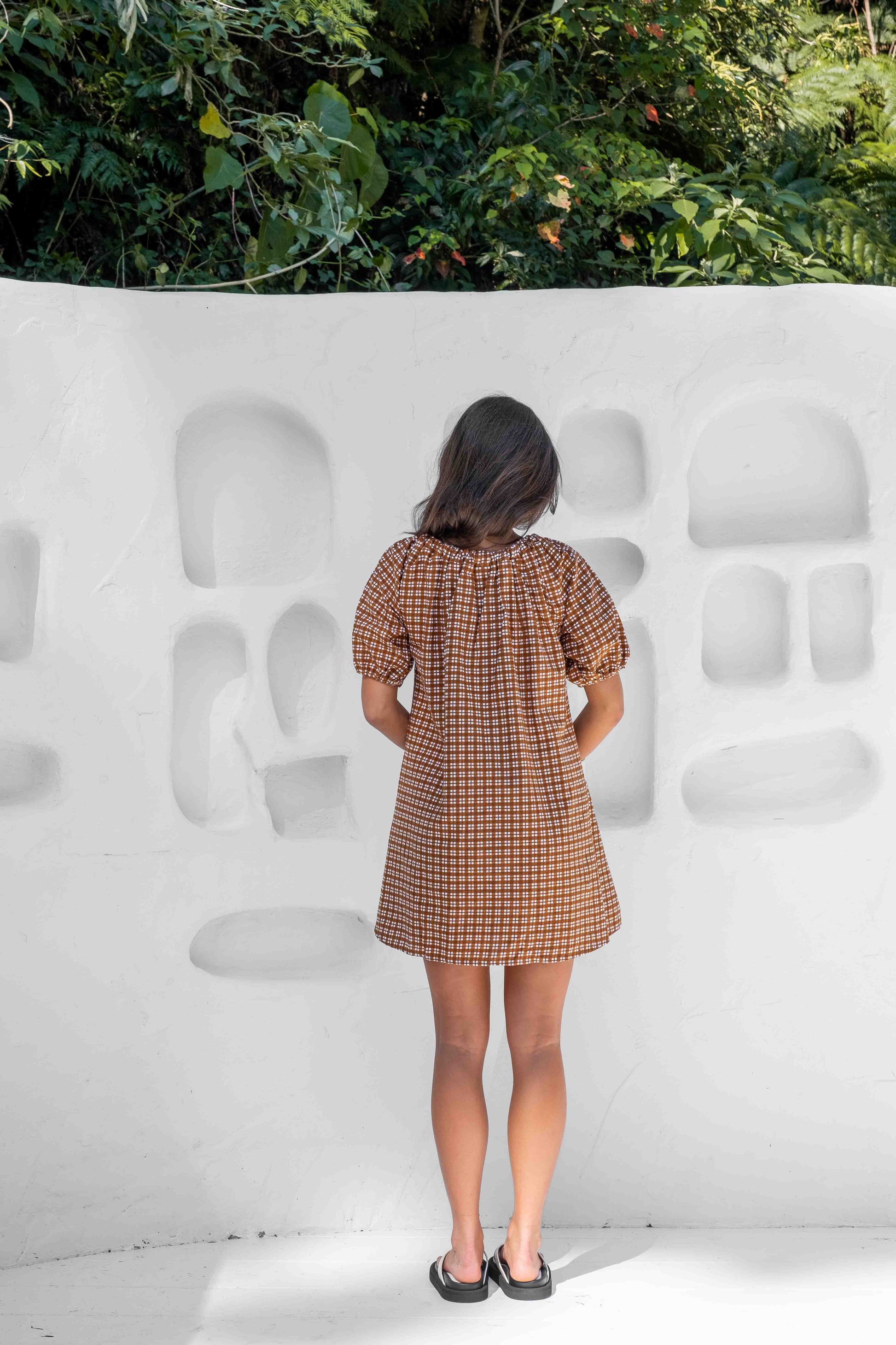 a line smock dress with a drawstring neckline and statement tie at the front puffy short sleeves in a beautiful brown gingham linen cotton fabric