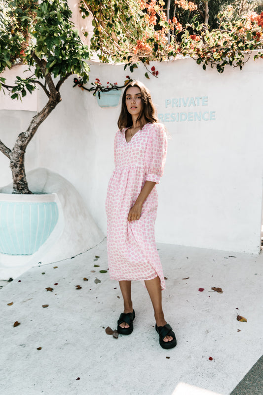 womens v neck smock dress made from 100% highest quality sustainable ramie fabric. A flattering cut with an adjustable back tie. Puffed 3/4 sleeves and a drop waist with a midi dress length. Super comfortable dress in a floral pink flower print. 