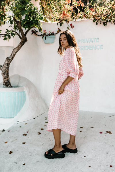 womens v neck smock dress made from 100% highest quality sustainable ramie fabric. A flattering cut with an adjustable back tie. Puffed 3/4 sleeves and a drop waist with a midi dress length. Super comfortable dress in a floral pink flower print. 