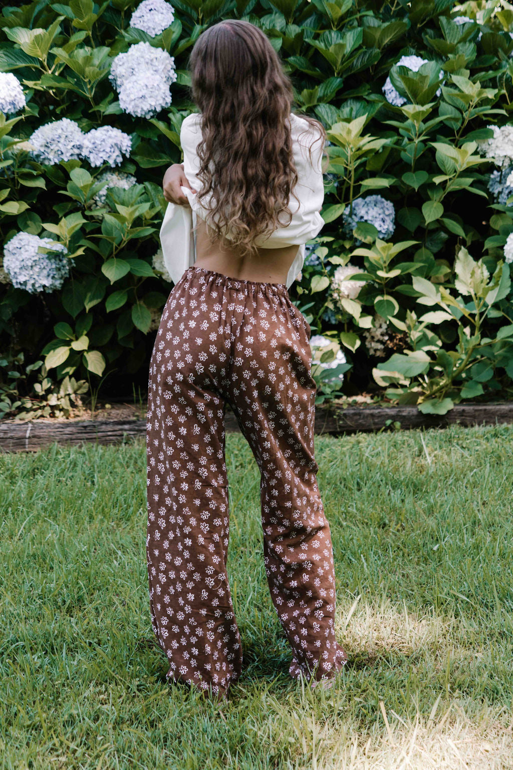 womens wide leg full length relaxed fit pant in a dark mocha brown cotton linen fabric with a hand painted flower print in white elastic waist with drawstring wide leg fit to the ankles