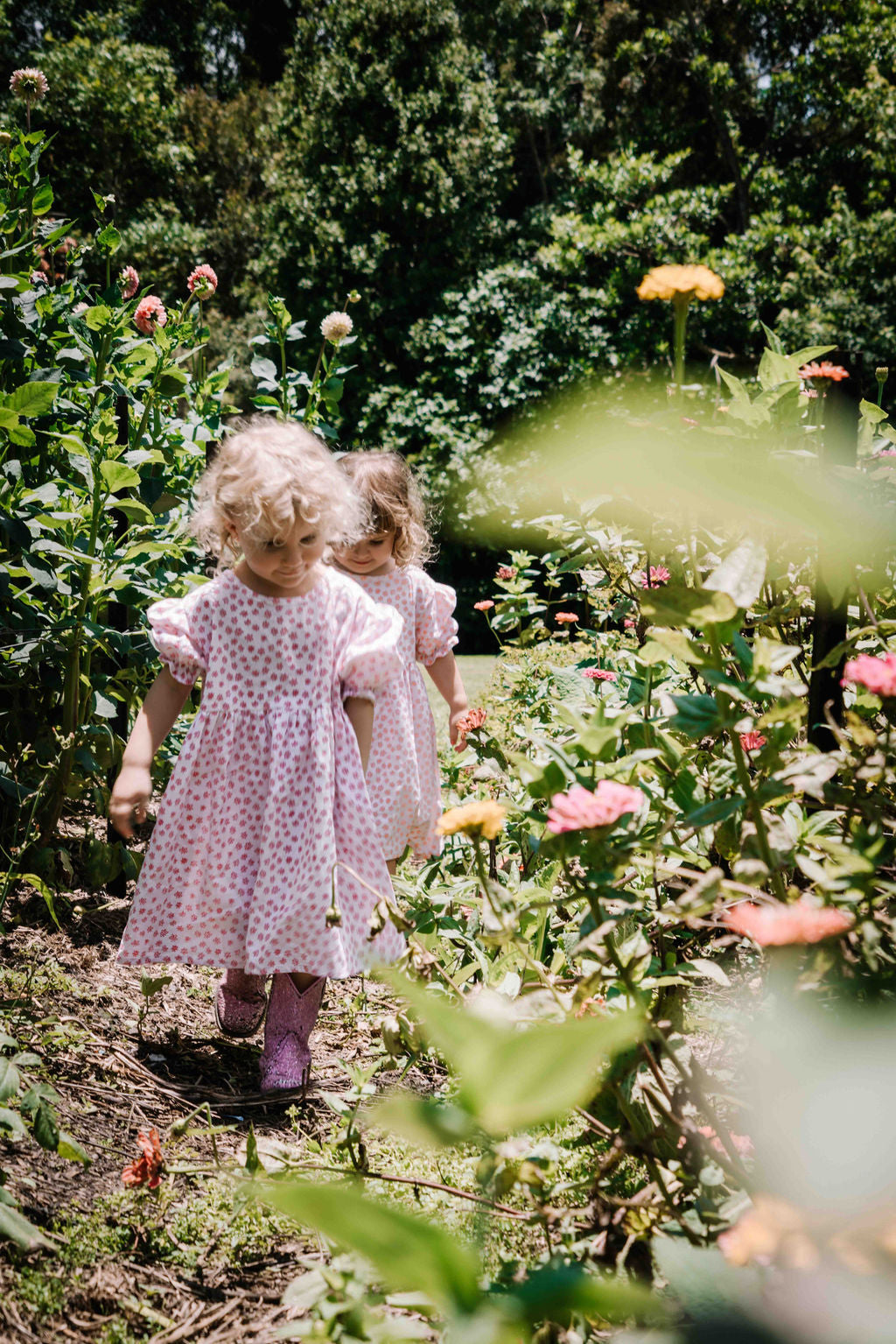 kids smock style dress in pink and white flower floral print with puff sleeves and adjustable back made from a cotton linen blend fabric thats soft 