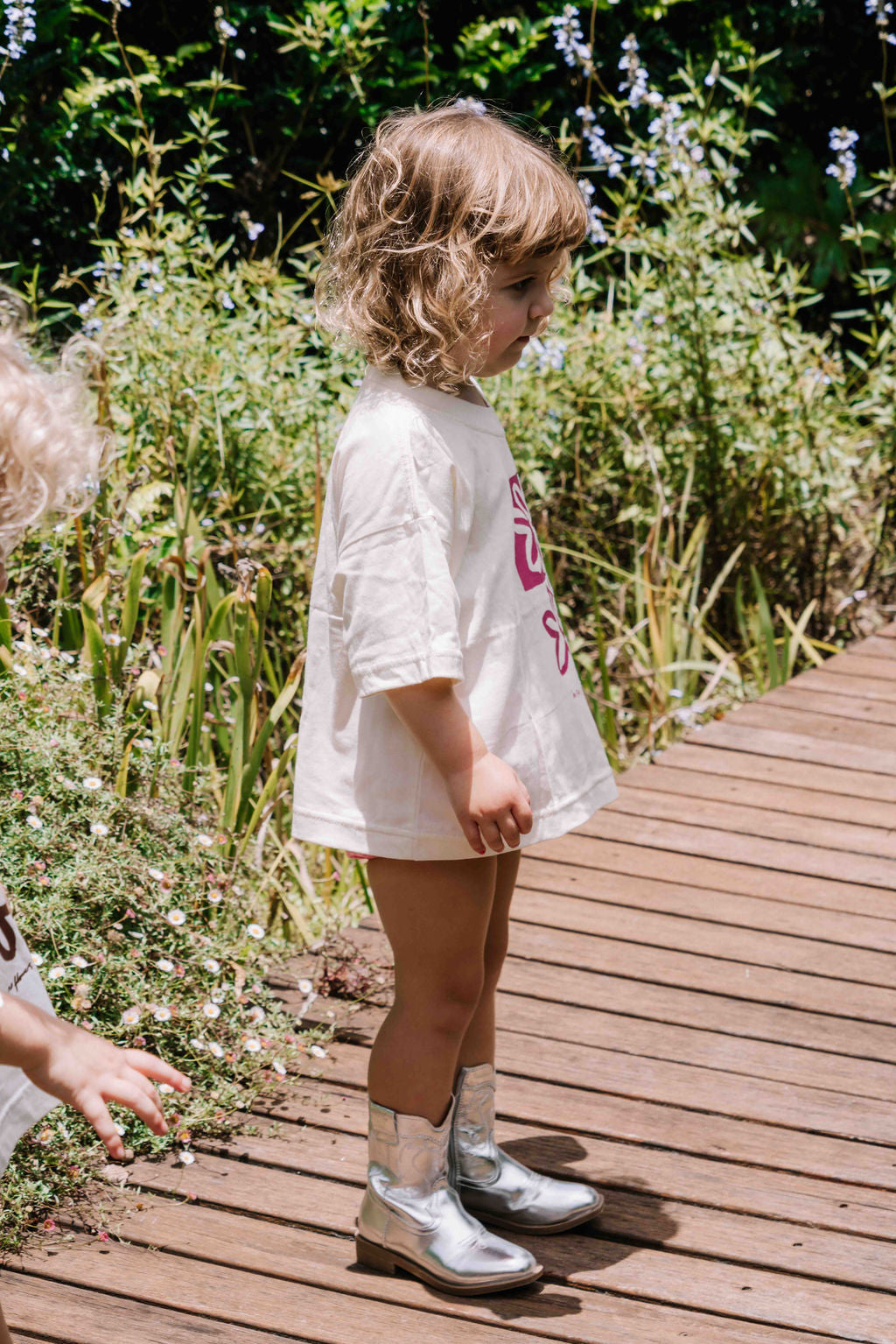 kids tshirt oversized fit with bold graphic hand painted logo in pink magenta on a  cream organic cotton tshirt comfortable boxxy fit soft fabric