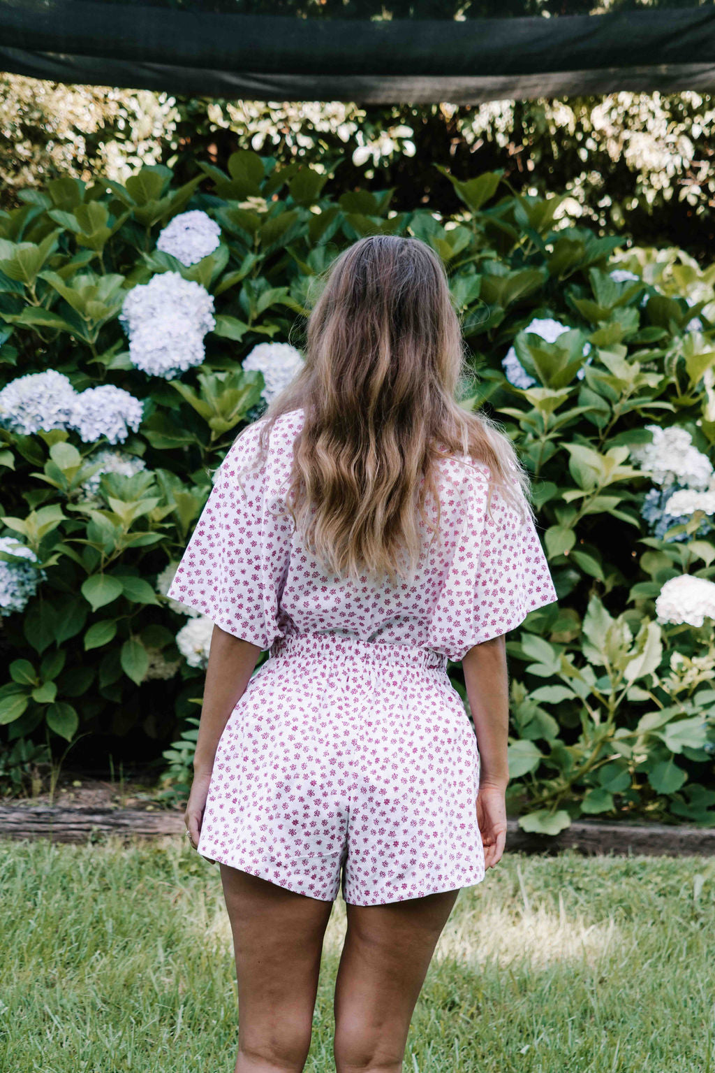 womens shorts with elastic waist and pockets, high waisted but can be worn lower small flower floral print in poink magenta colour on white background