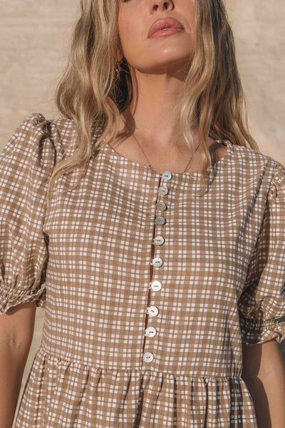 a brown gingham maxi dress with a statement puffed short sleeve with a frill detail, a rounded neckline with a button down front. Breastfeeding friendly style.