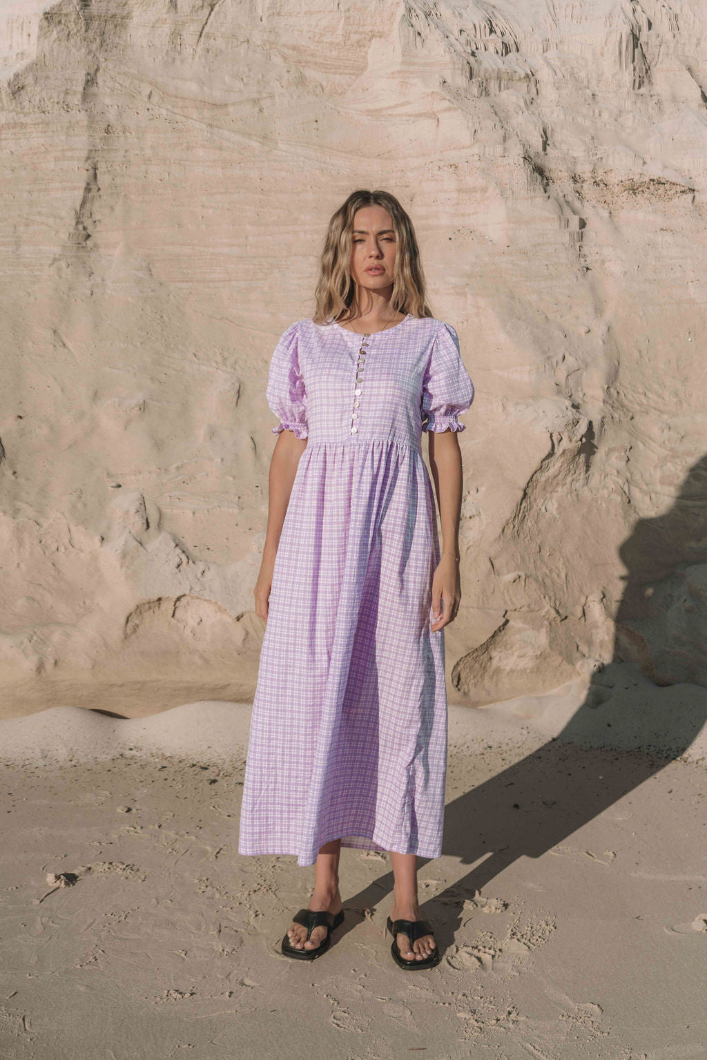 a lilac purple gingham maxi dress with a statement puffed short sleeve with a frill detail, a rounded neckline with a button down front. Breastfeeding friendly style.