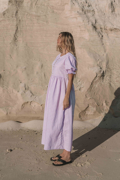 a lilac purple gingham maxi dress with a statement puffed short sleeve with a frill detail, a rounded neckline with a button down front. Breastfeeding friendly style.