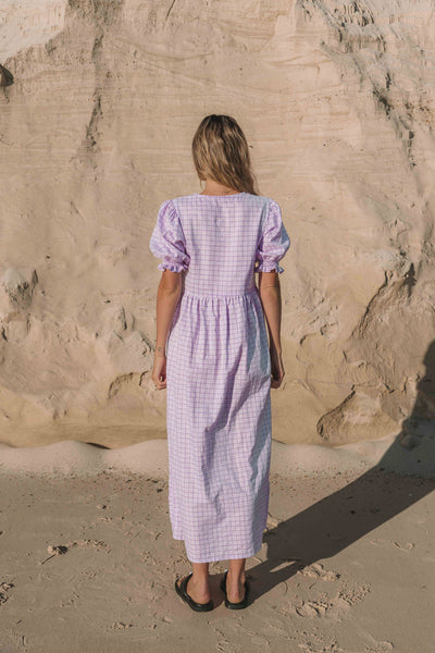 a lilac purple gingham maxi dress with a statement puffed short sleeve with a frill detail, a rounded neckline with a button down front. Breastfeeding friendly style.