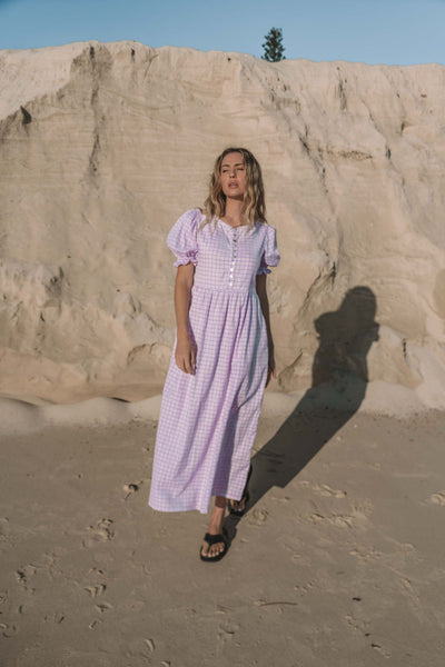 a lilac purple gingham maxi dress with a statement puffed short sleeve with a frill detail, a rounded neckline with a button down front. Breastfeeding friendly style.