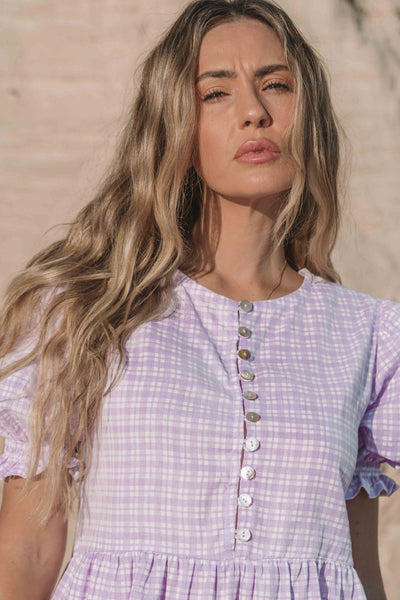 a lilac purple gingham maxi dress with a statement puffed short sleeve with a frill detail, a rounded neckline with a button down front. Breastfeeding friendly style.