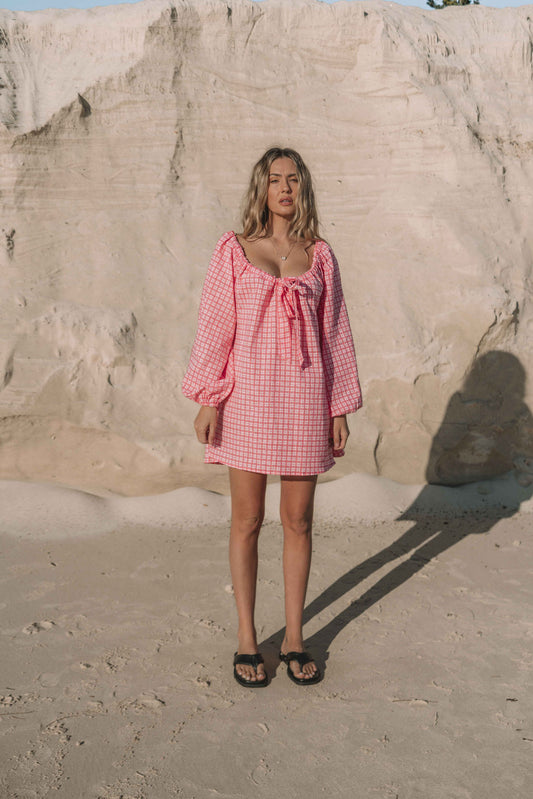 pink gingham mini dress with a statement balloon long sleeve, rounded neckline with adjustable bow tie at the front