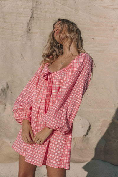 pink gingham mini dress with a statement balloon long sleeve, rounded neckline with adjustable bow tie at the front