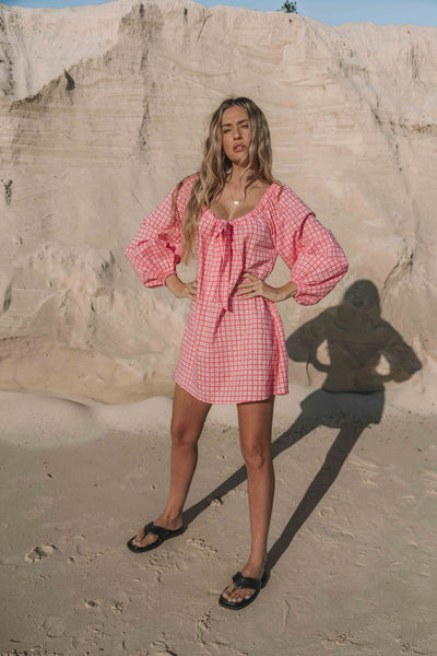 pink gingham mini dress with a statement balloon long sleeve, rounded neckline with adjustable bow tie at the front