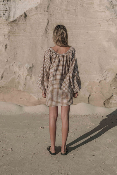 a brown gingham mini dress with a statement balloon long sleeve, rounded neckline with adjustable bow tie at the front