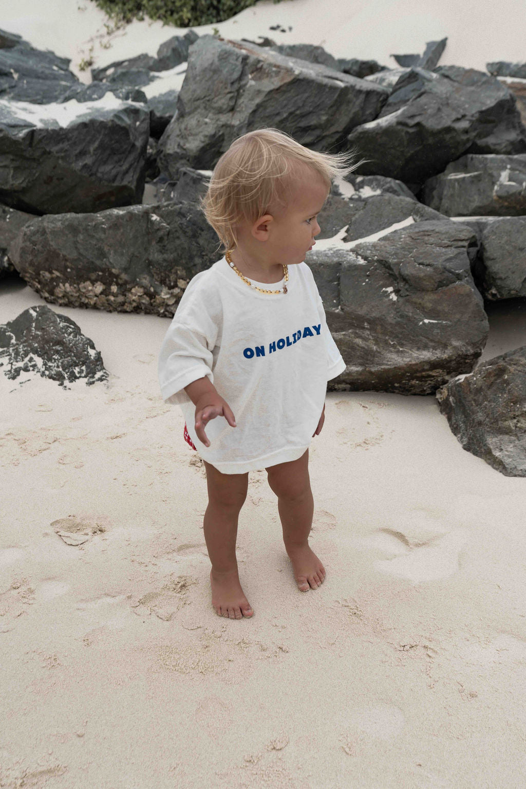 Children's t-shirt made from soft 100% orgaic cotton in a off white oversized fit with blue ‘ON HOLIDAY’ graphic. The shirt has a relaxed, comfy fit.