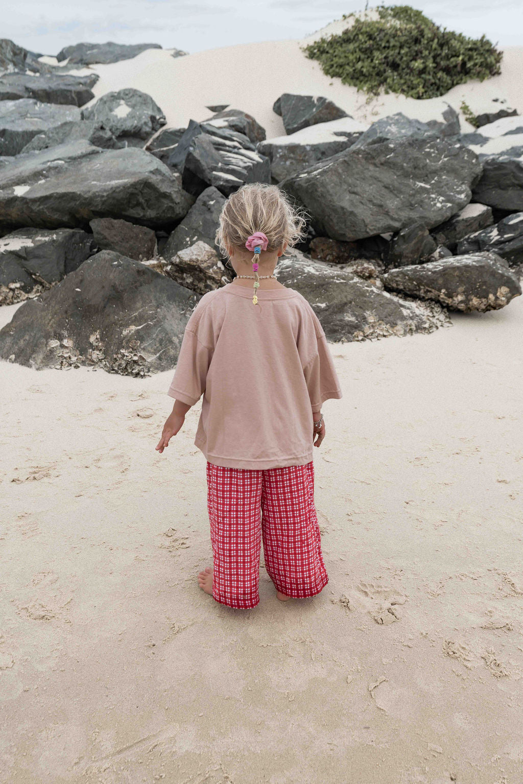 Children's t-shirt made from soft 100% orgaic cotton in a dusty pink oversized fit with red ‘ON HOLIDAY’ graphic. The shirt has a relaxed, comfy fit.