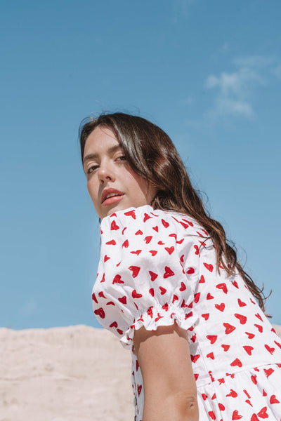 womens mini dress smock in red and white heart print with puff sleeves and adjustable back ties can be worn reversed has a button down front and is breastfeeding friendly