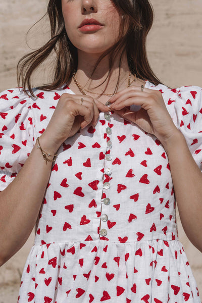 womens mini dress smock in red and white heart print with puff sleeves and adjustable back ties can be worn reversed has a button down front and is breastfeeding friendly