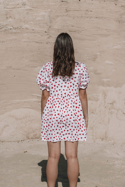 womens mini dress smock in red and white heart print with puff sleeves and adjustable back ties can be worn reversed has a button down front and is breastfeeding friendly